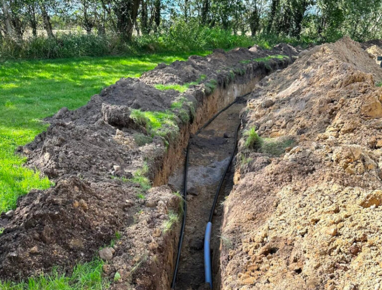 Jordvarmeslanger nedgravet i jord under installation